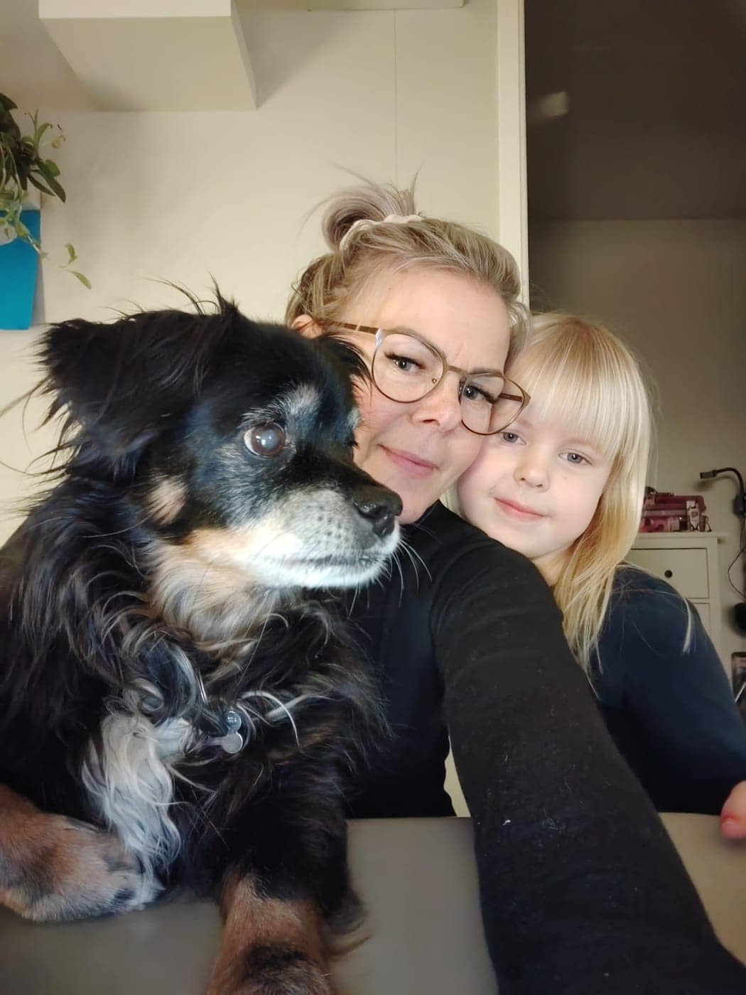 Kapahoidi perenaine ja tema tütar koos oma koeraga kodus